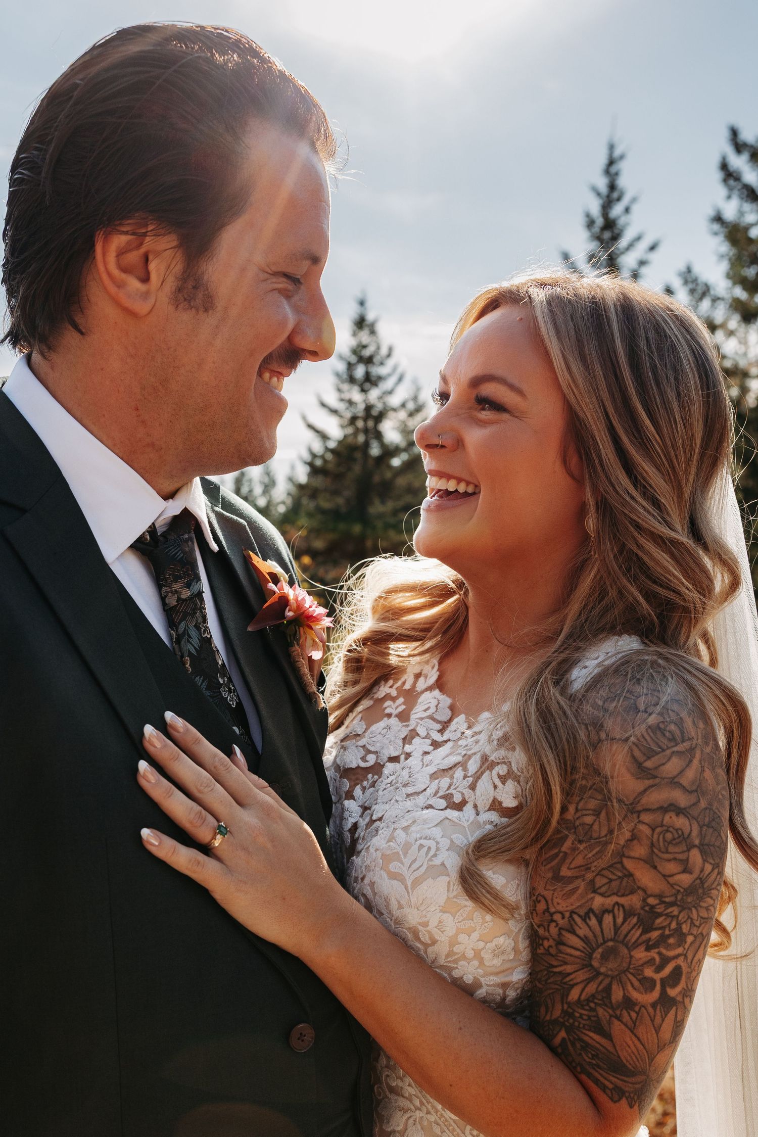 A joyful couple shares intimate moments together during their outdoor wedding photoshoot at sunset.