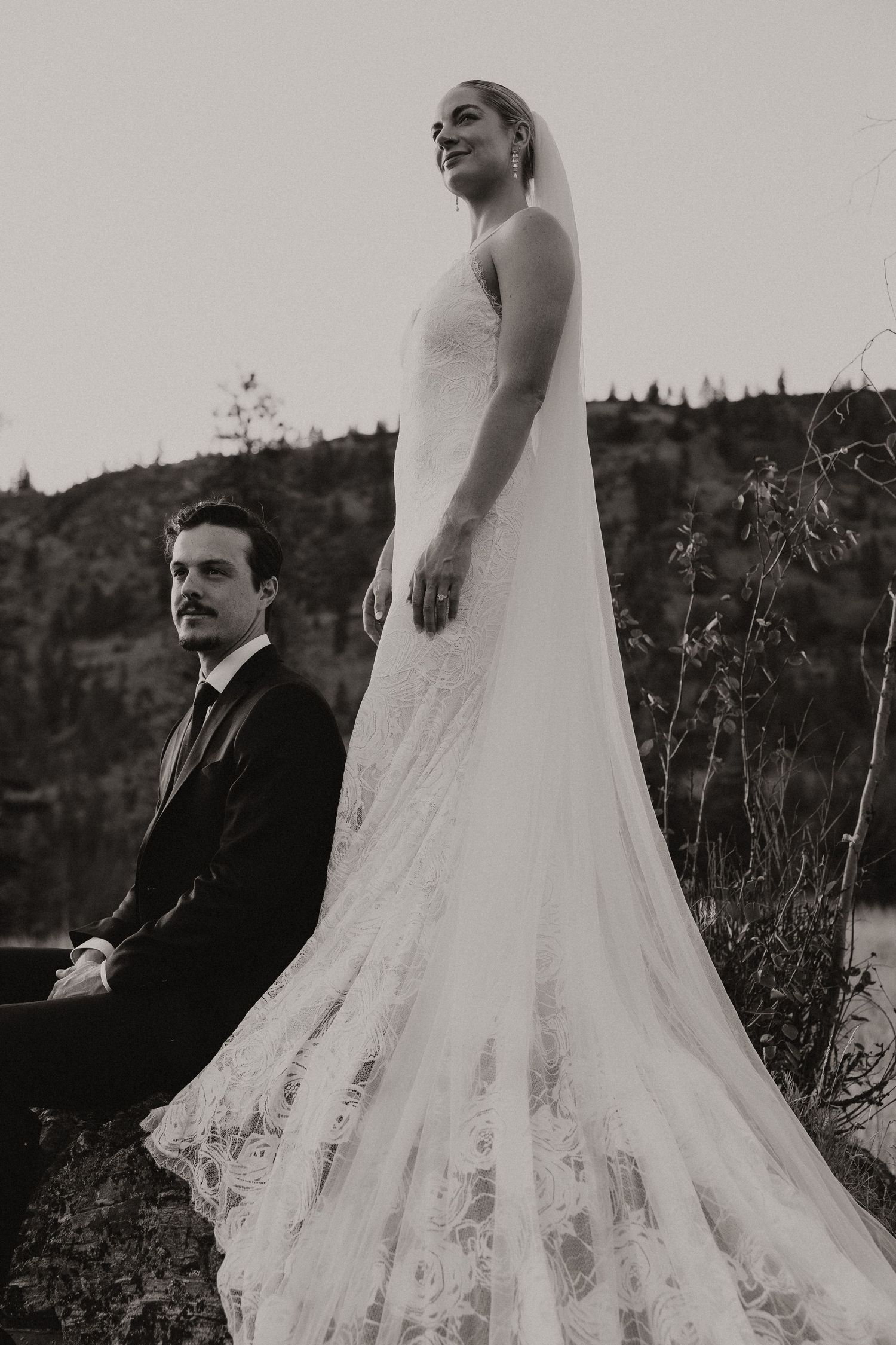 A black and white series of wedding photos showing a bride's flowing lace dress train against a natural outdoor backdrop.