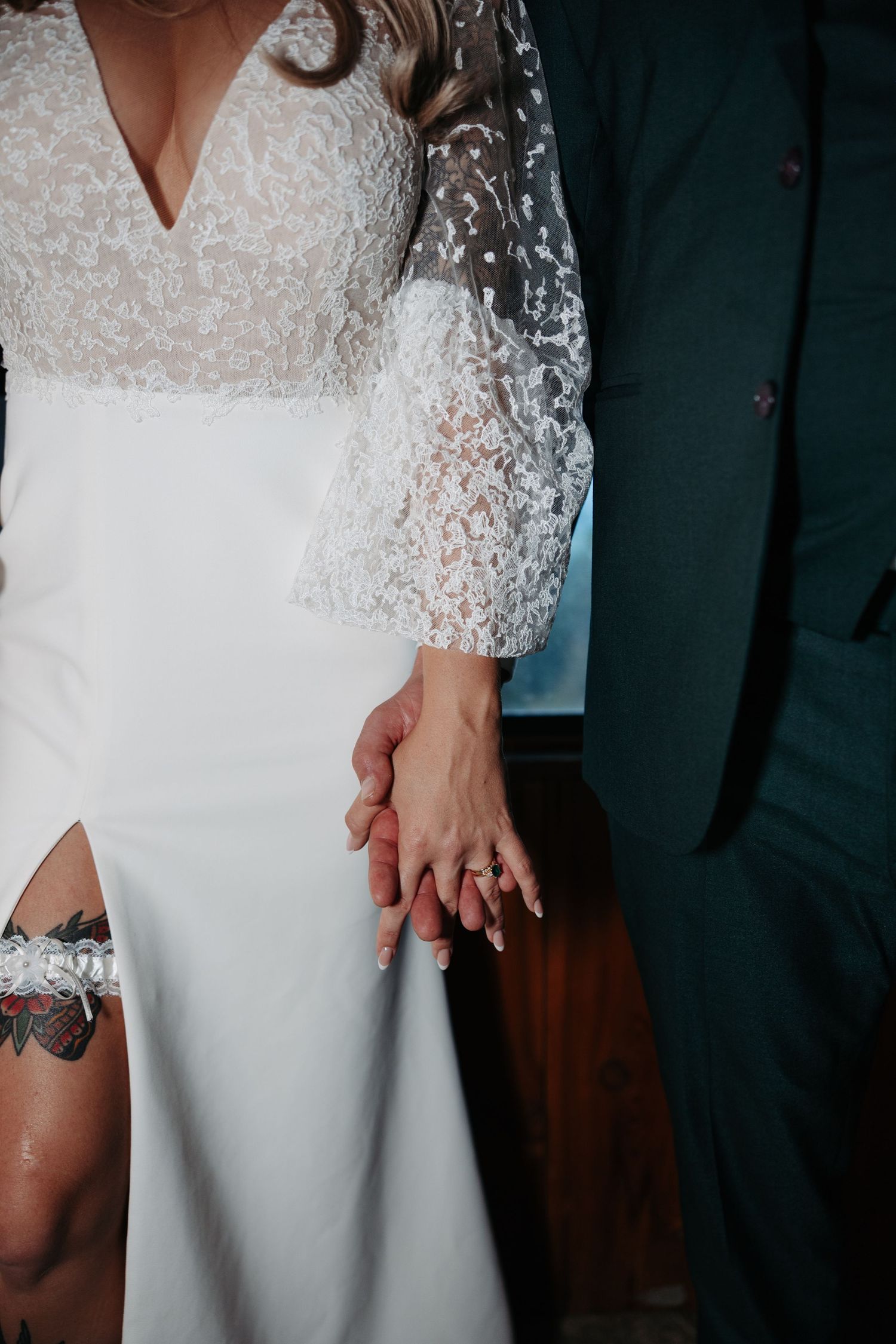 Close-up details of an elegant white wedding dress with delicate lace sleeves and beading.