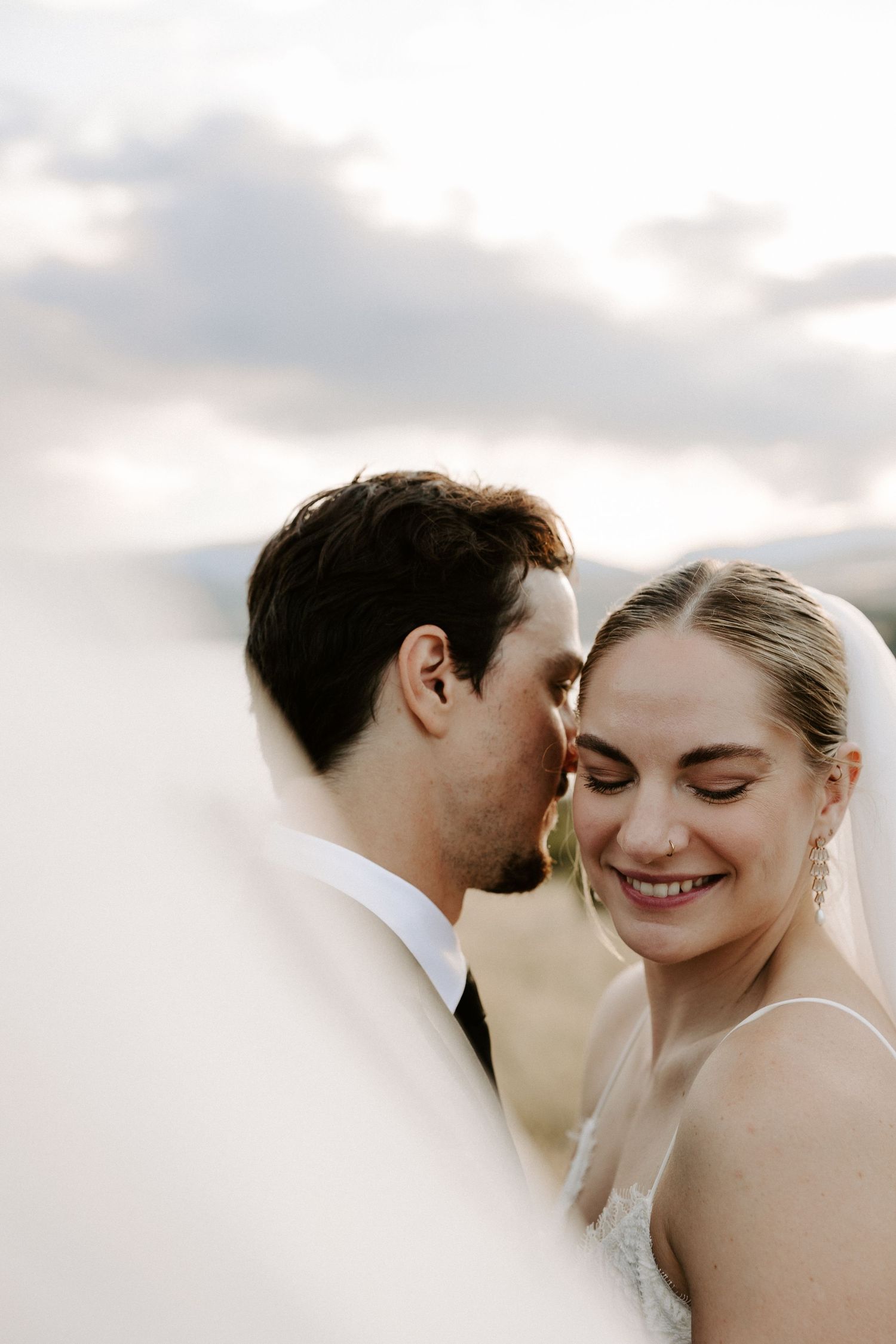 A romantic series of intimate wedding portraits showing a couple in tender moments against a cloudy sky.