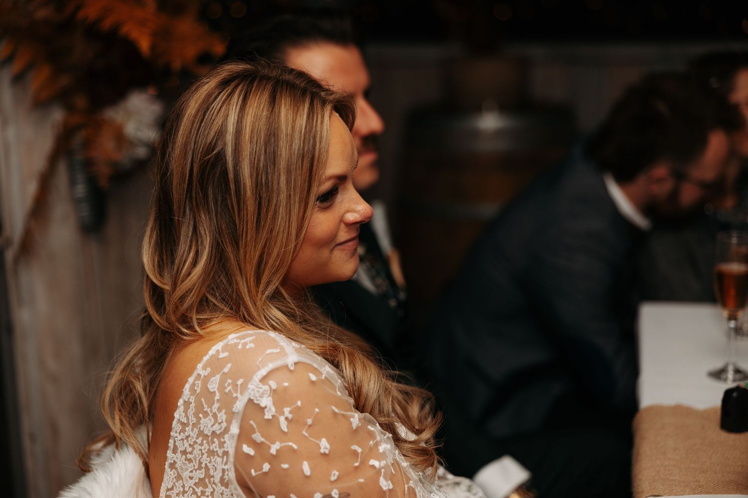 Side view of a wedding dress showing intricate lace detailing and flowing fabric in natural light.