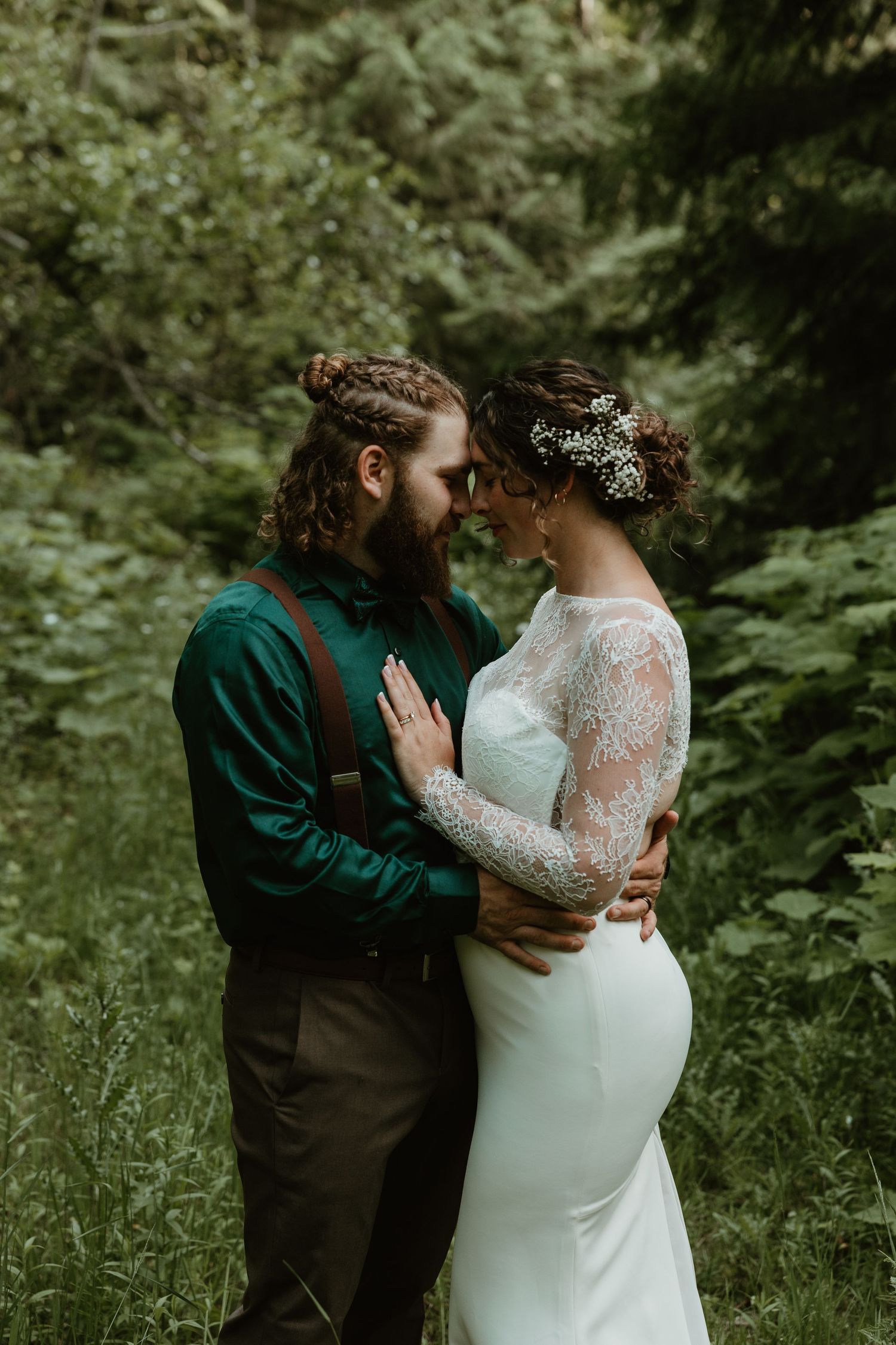 A romantic forest wedding portrait with the couple in elegant attire.