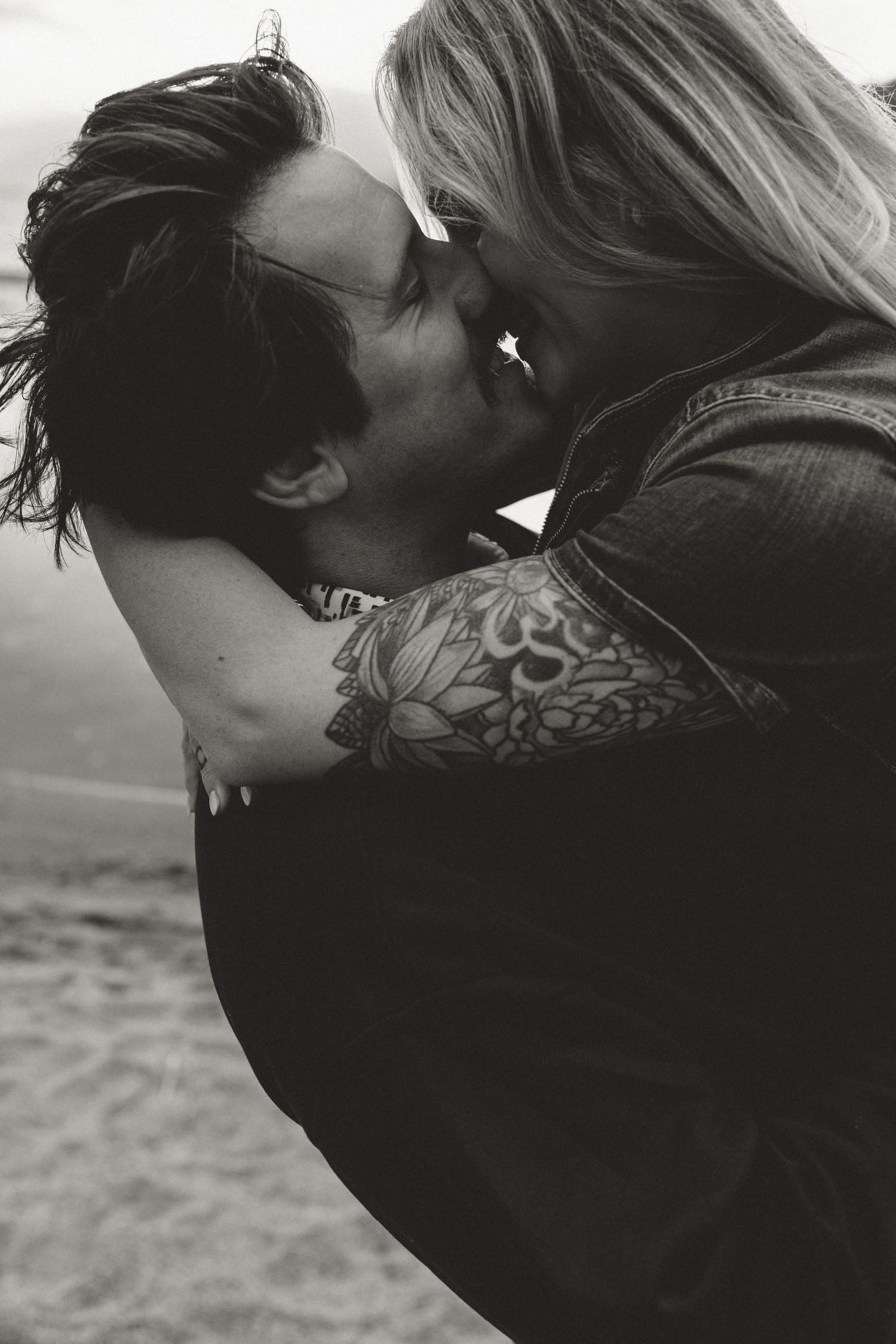 An intimate black and white portrait of a couple sharing a romantic moment.