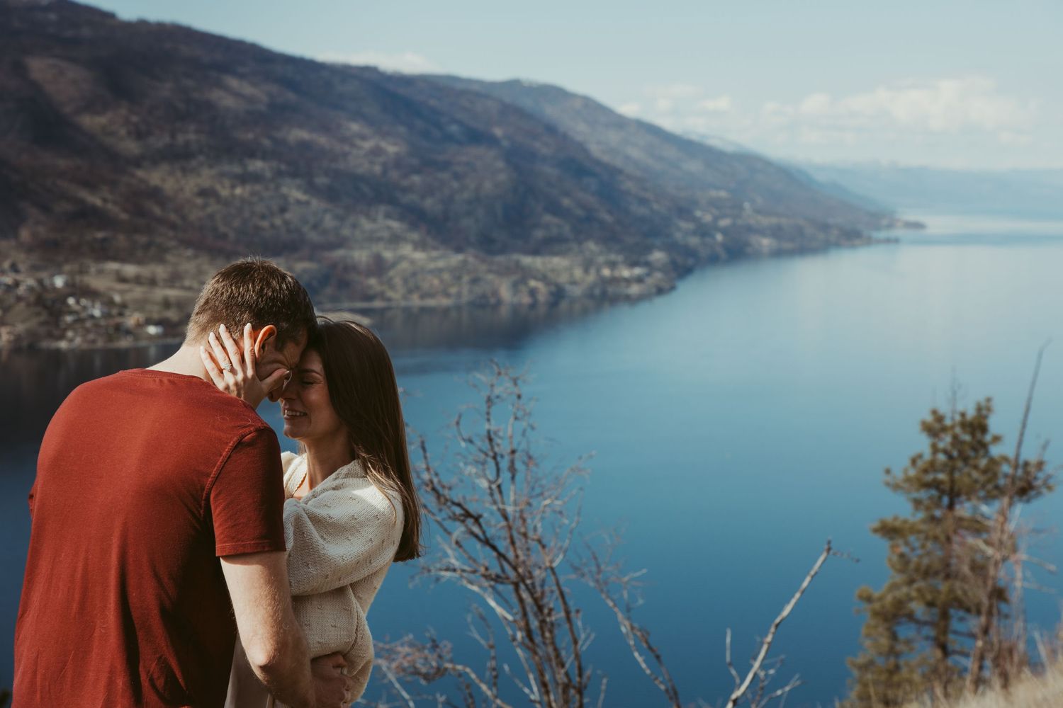 Romantic embrace overlooking scenic mountain lake vista.