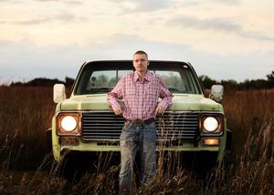 A classic mint green car photographed in a field during golden hour.