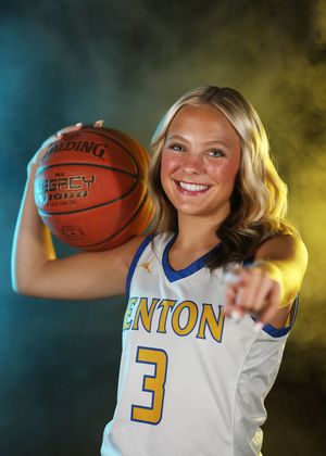 Fenton #3 female basketball player in white jersey smiles while holding Spalding ball and pointing at camera.