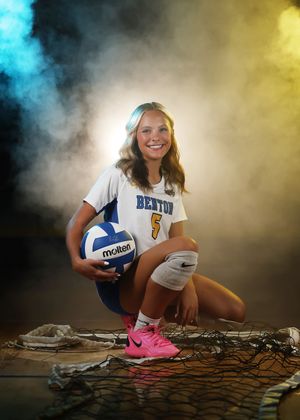 Benton volleyball player #5 poses with a Molten ball in uniform against a dramatic smoky blue and yellow backdrop.