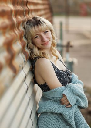 A series of portrait shots showing someone in a blue knit sweater and black top posing against a blurred background.
