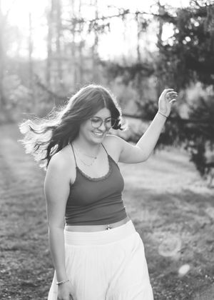 Dancing with hair flowing in a black and white outdoor portrait.