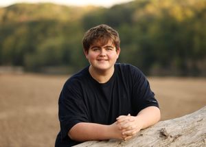 Casual outdoor portrait against a natural background with warm lighting.