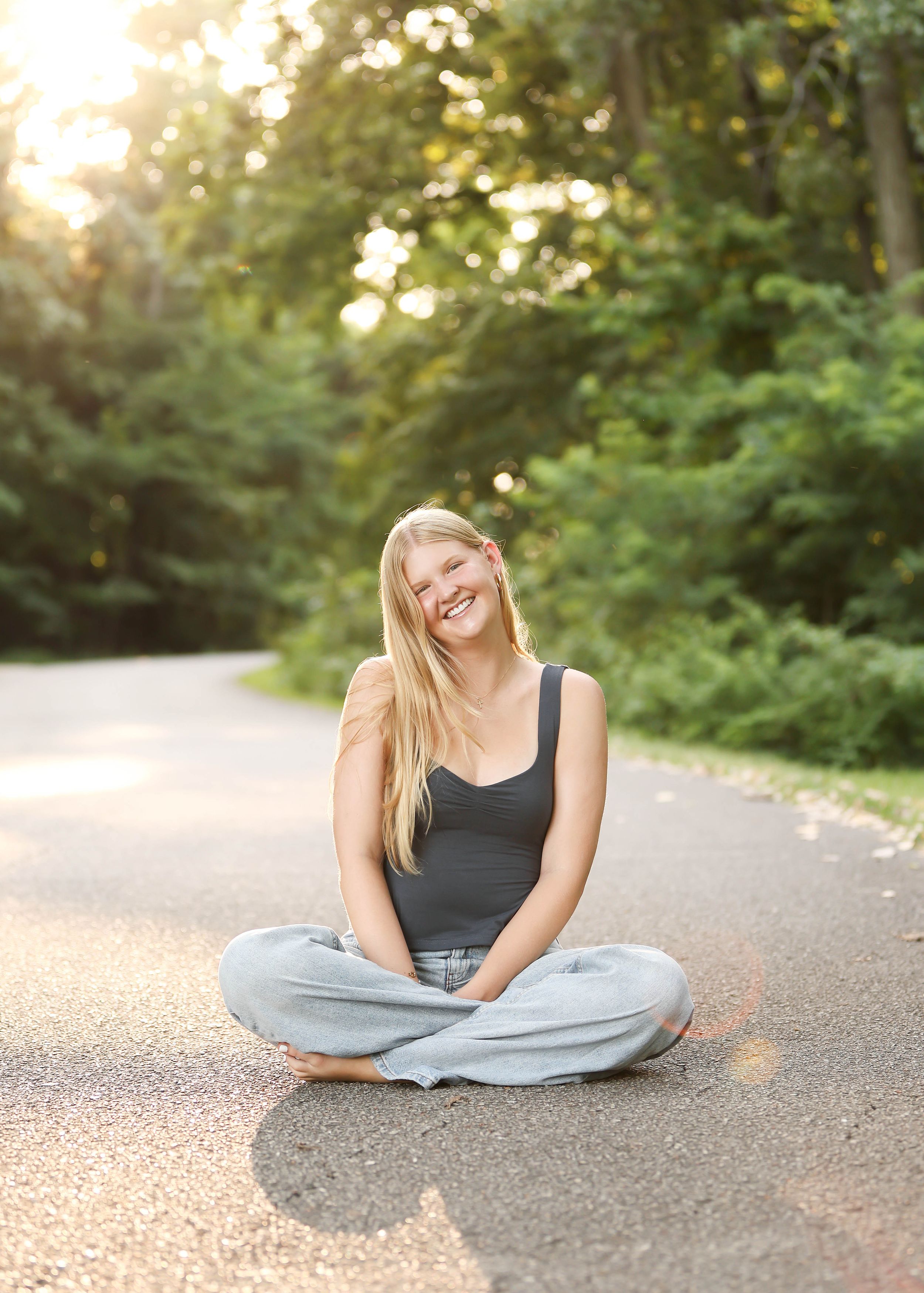 Casual outdoor portraits on path with light-filled natural backdrop.