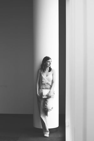 Artistic black and white portrait in a minimalist architectural setting.