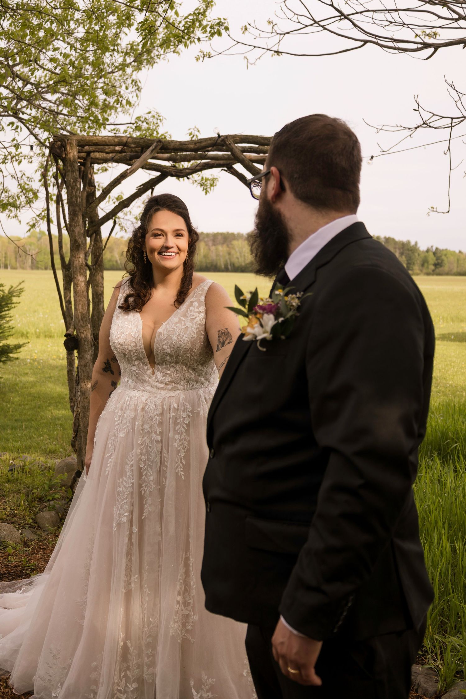 Winter wedding portrait of a couple with a white floral bouquet in a snow-covered forest.
