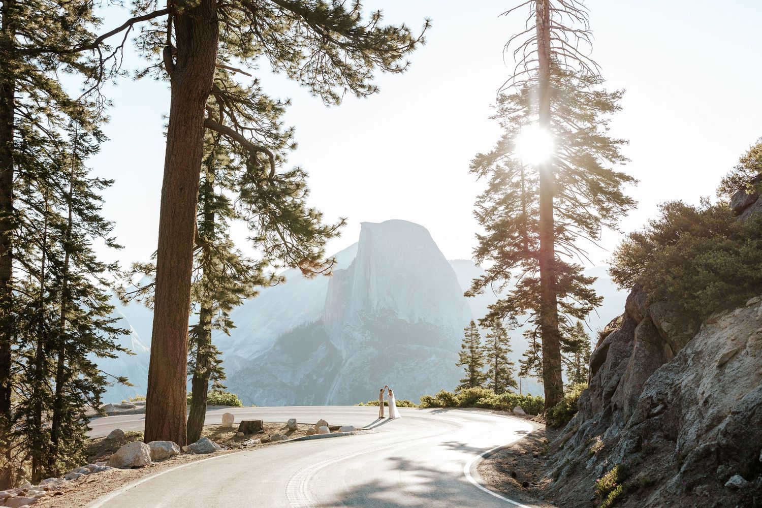 Yosemite Elopement Photographer - A bride and groom are running in a field in Yosemite valley with Half Dome behind them