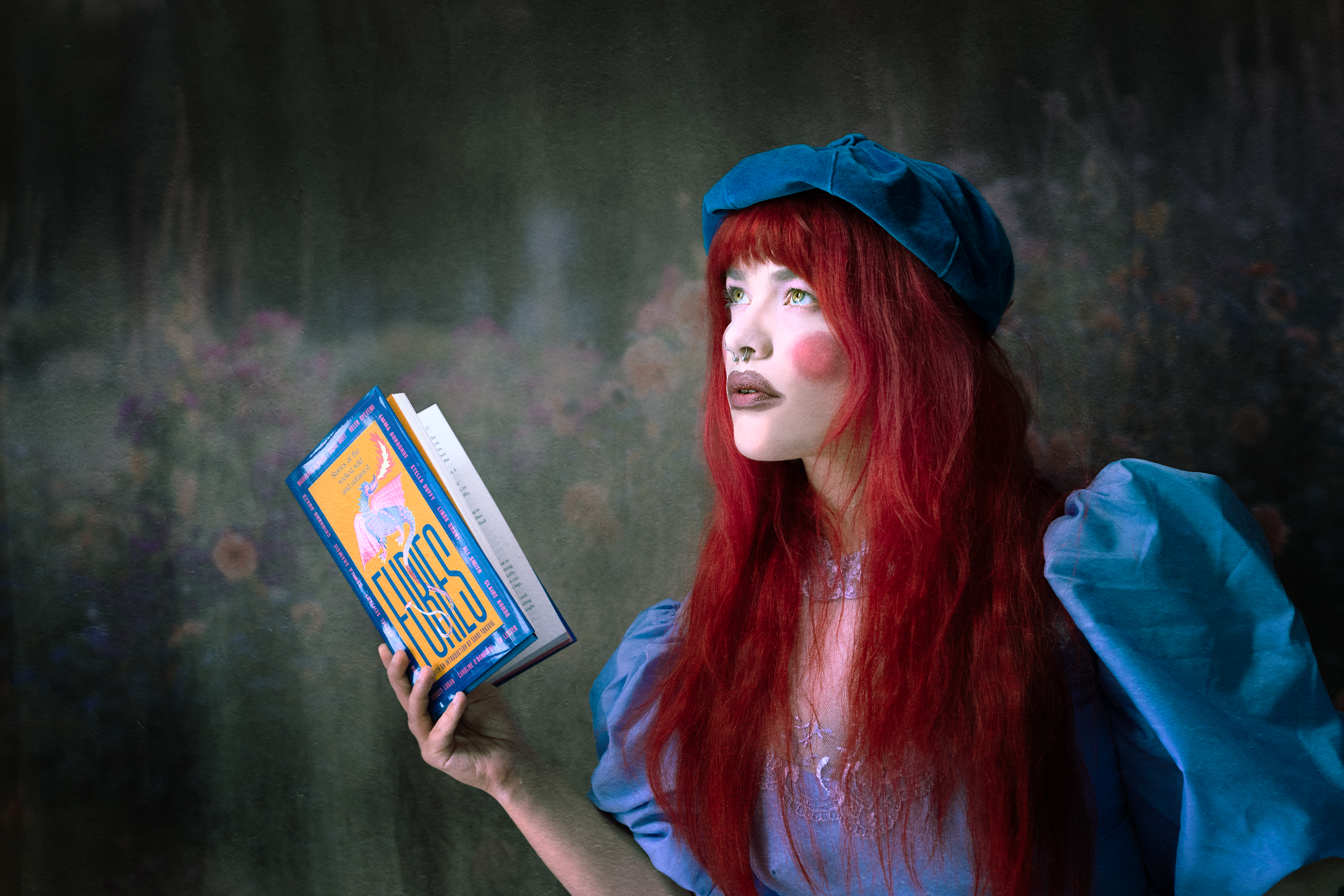 Whimsical scene with blue accessories and book in moody lighting.