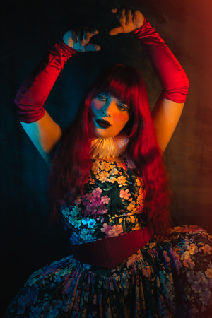 Artistic portrait with dramatic red and blue lighting creating a moody atmosphere with floral elements.