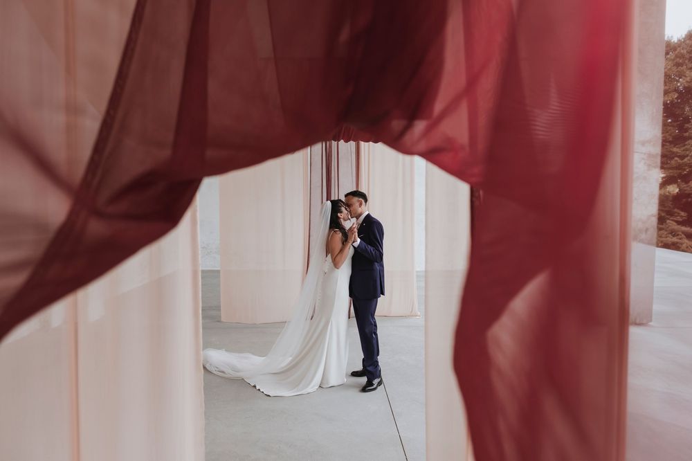Flowing burgundy fabric creates dramatic movement in an indoor setting.