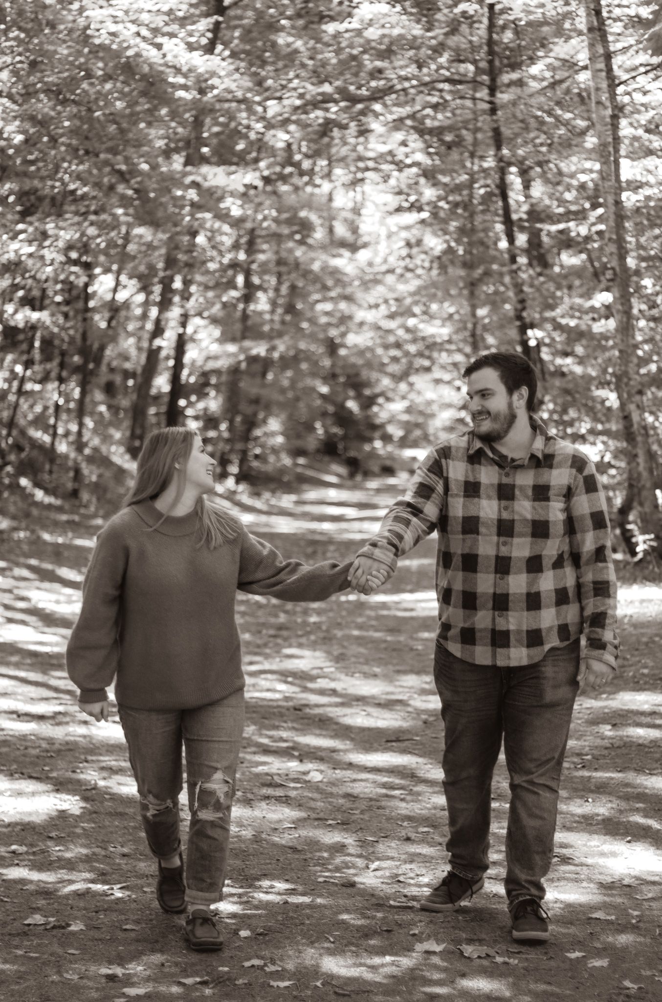 Sapia image of couples, smiling, and holding hands in a forest in New Hampshire