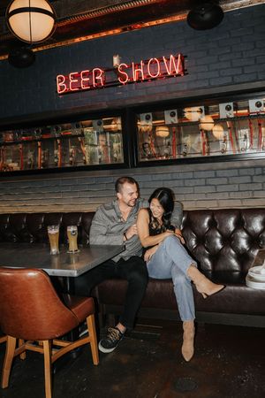 A sequence of photos showing a person falling off a bar stool in a dimly lit pub with brick walls and neon signs.