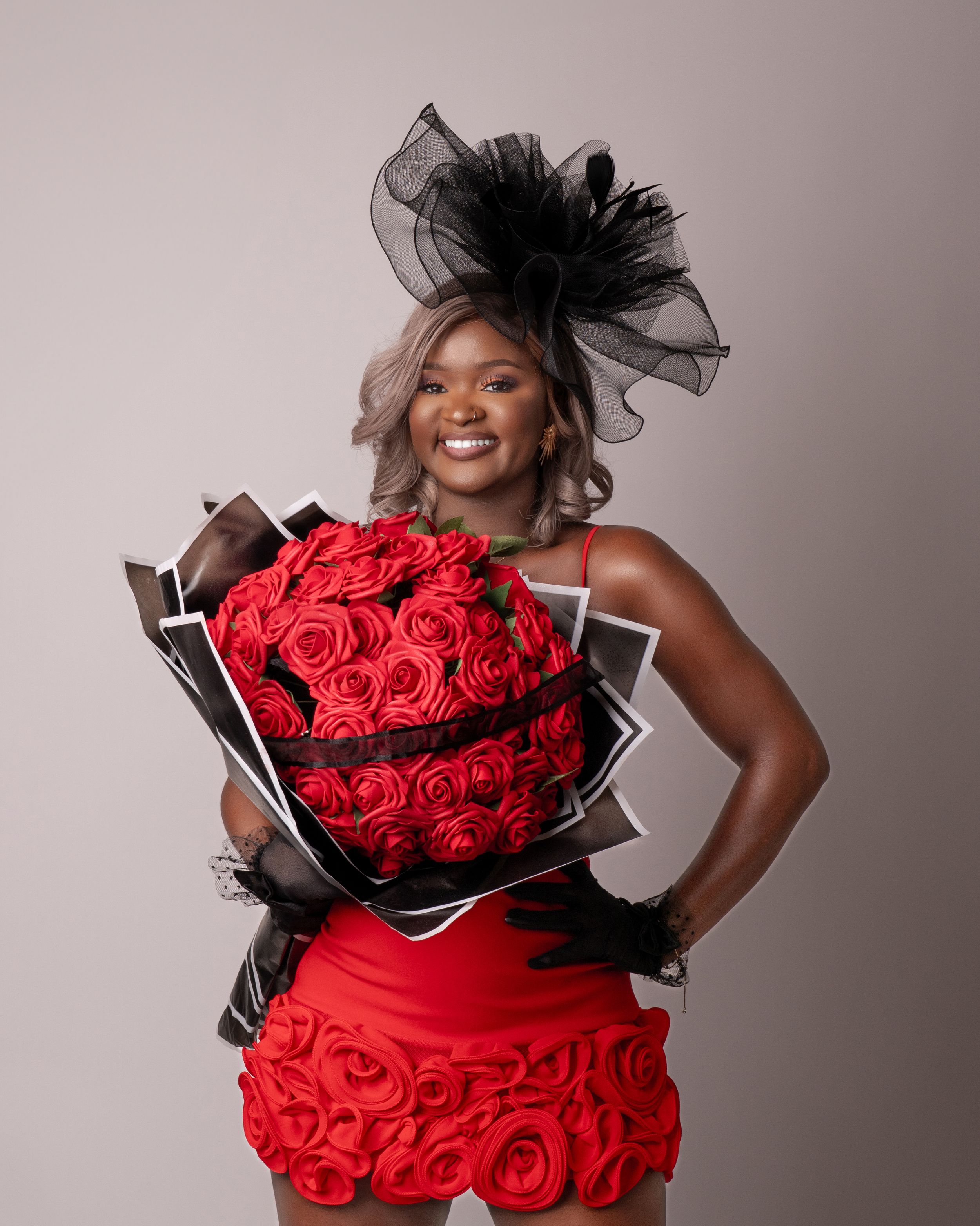 A glamorous red rose bouquet with black accents is displayed in a series of four studio portraits.