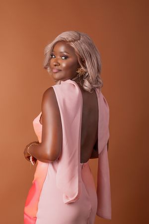 Model wearing pink sleeveless top poses against warm brown backdrop in fashion photoshoot sequence.