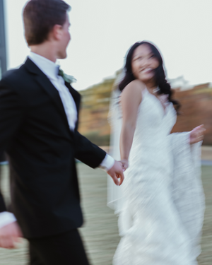 A motion-blurred wedding couple dances gracefully in formal attire on their special day.