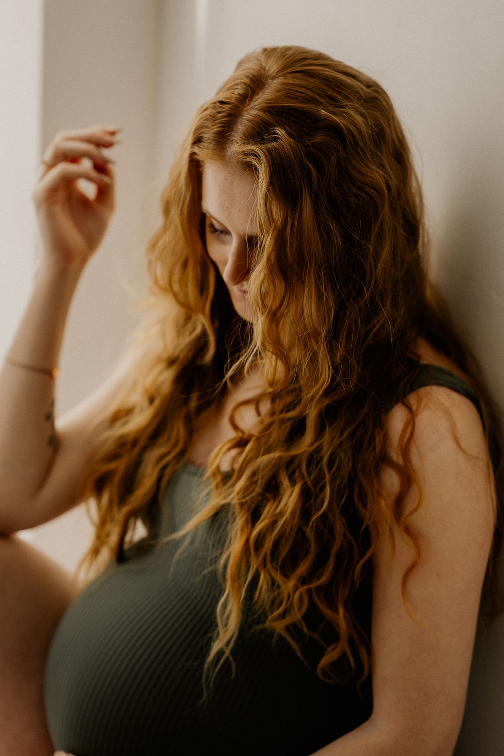 Artistic portrait series showing wavy hair movement against a warm neutral background in moody lighting.