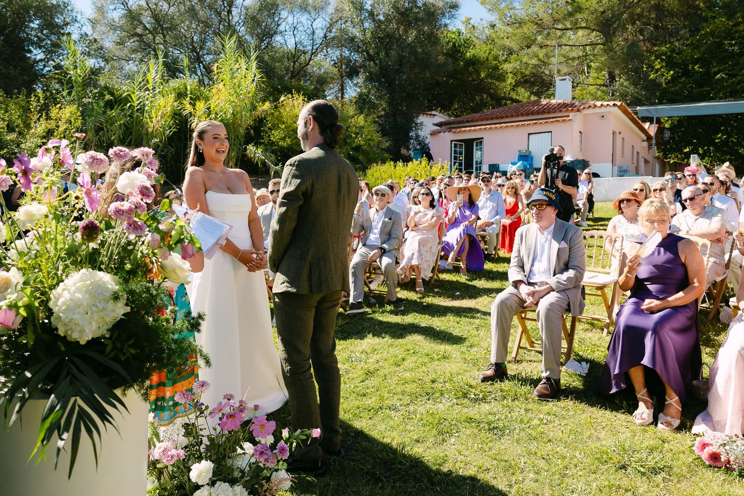 A newlywed couple poses outdoors against a blue sky during golden hour.