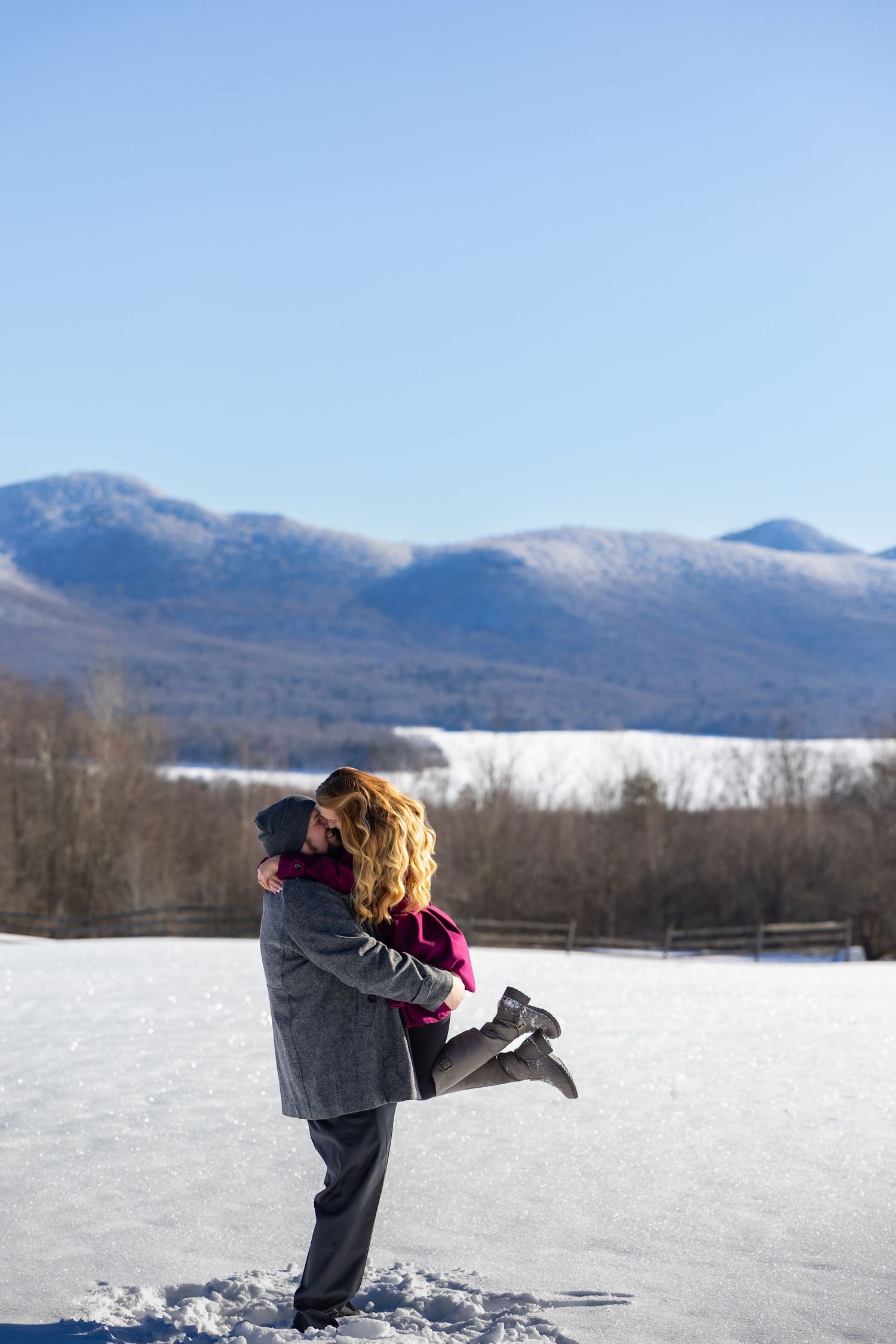 Couple shares an intimate moment outdoors with fall foliage in the background.