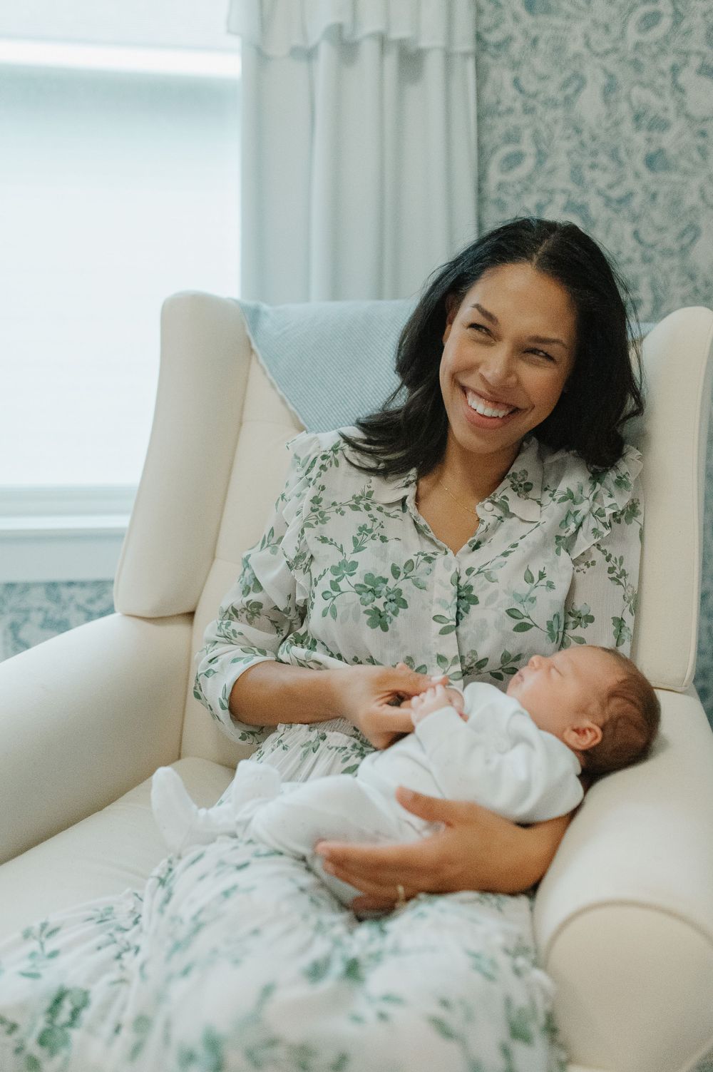 A joyful moment shared between mother and baby as they relax in a cozy nursery chair.