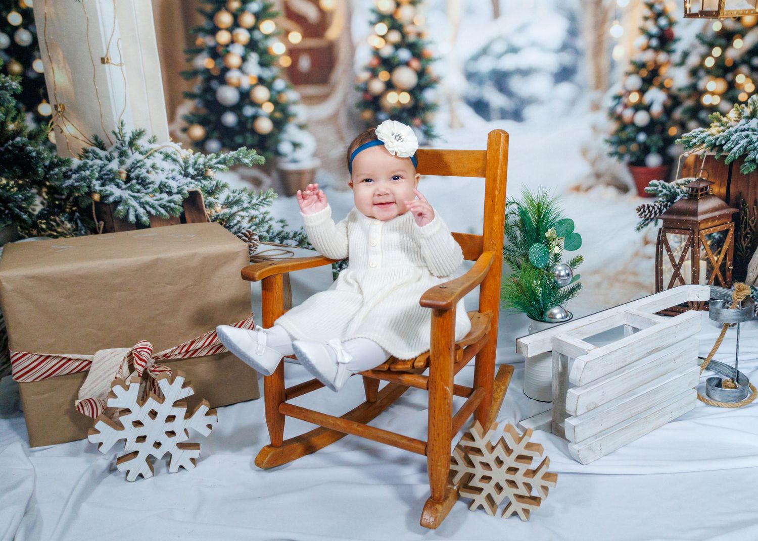 Holiday themed photo setup with white rocking chair and snowflake decorations.