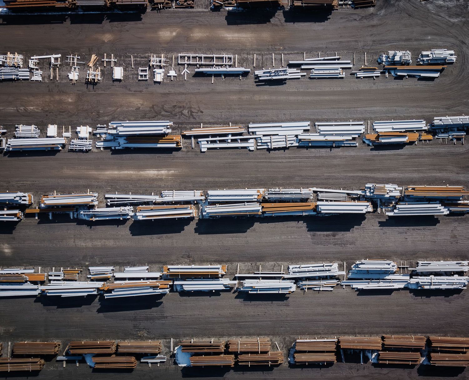 Aerial view of school buses parked in rows at a large transportation depot or storage facility.