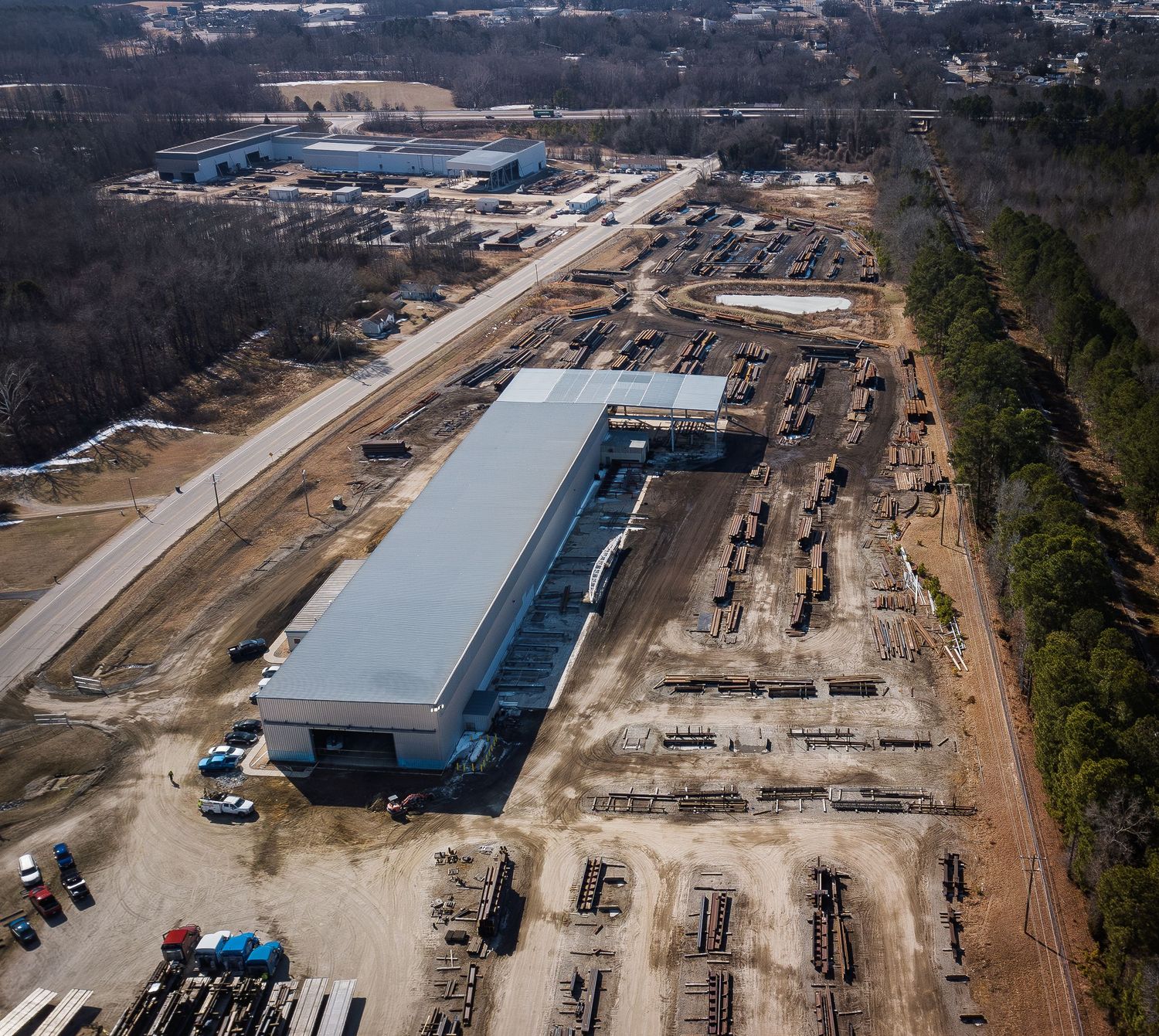 Aerial view of industrial construction site with multiple buildings and equipment in various stages of development.