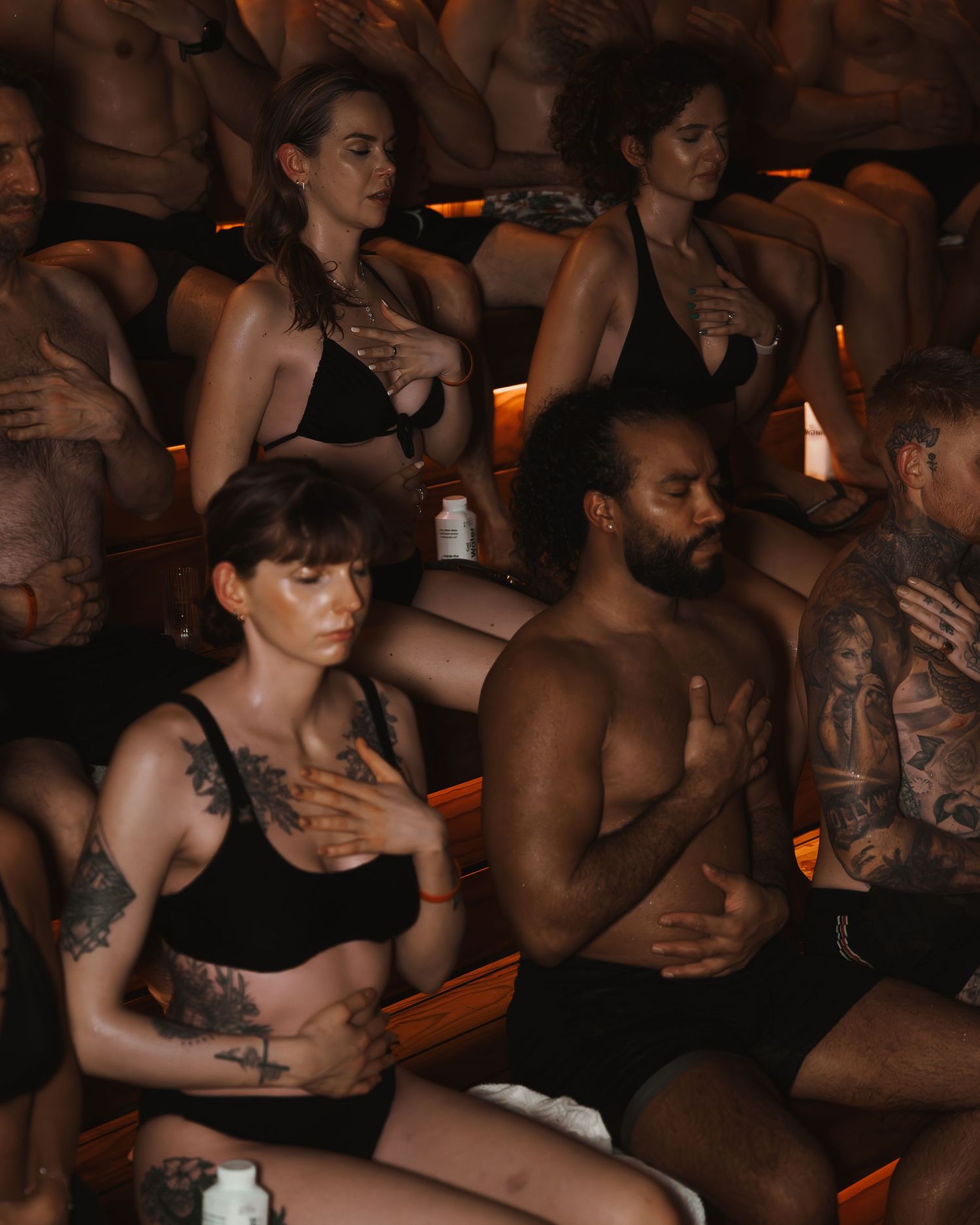 People practicing breathwork exercises in a dimly lit room with warm ambient lighting.