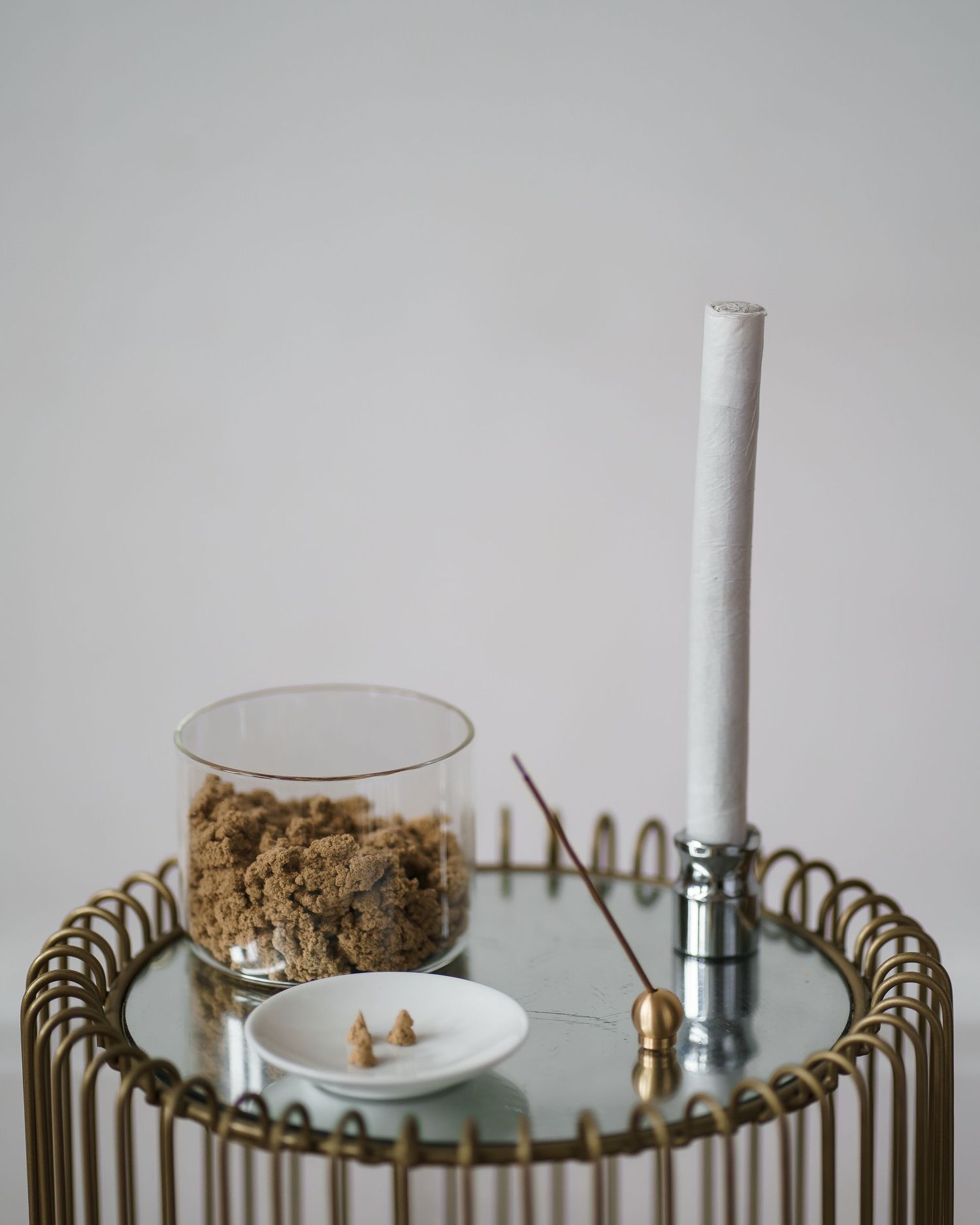 Close-up view of decorative gold candle holders with white candles arranged on a mirrored surface.