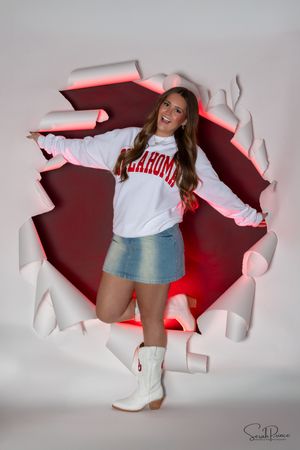Creative photo series shows a person breaking through a white paper wall wearing blue shorts and white boots.
