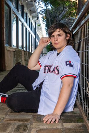 Person in white Texas Rangers baseball jersey posing on concrete floor in three casual poses.