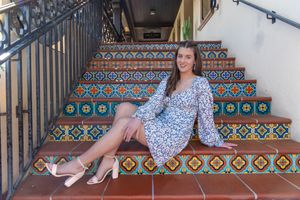 A floral dress and heels outfit photographed on decorative Spanish tile stairs with colorful geometric patterns.