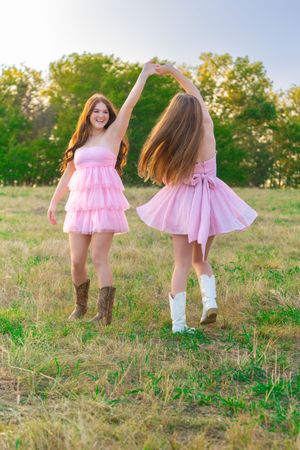 A series of photos showing someone in a pink tulle dress and brown cowboy boots twirling playfully in a sunlit field.