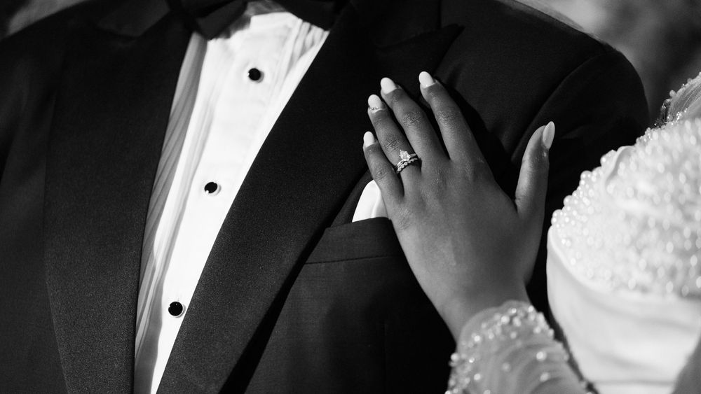 Close-up of hands embracing during a formal wedding ceremony.
