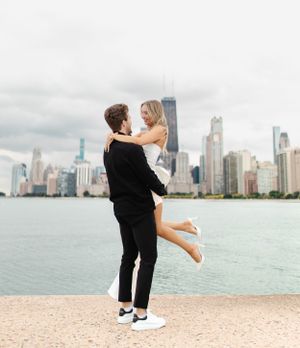 Romantic couple embracing by Lake Michigan with Chicago's iconic skyline behind them.