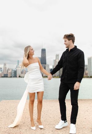 Couple in contrasting black and white outfits pose along Chicago's waterfront.