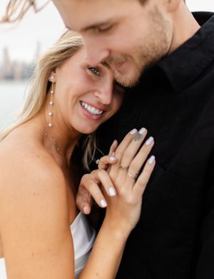 Close-up of a romantic embrace against a blurred city backdrop.