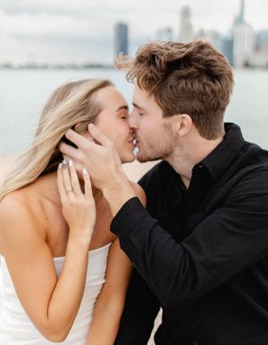 Intimate moment captured between couple with Lake Michigan and city skyline in background.