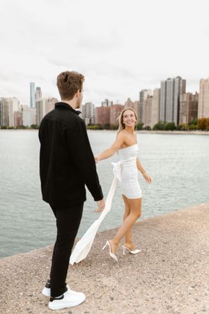 Couple in black and white outfits pose along Chicago's lakefront path.