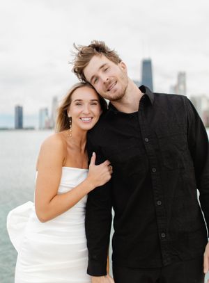 Happy couple poses casually with Chicago's lakefront skyline in the background.