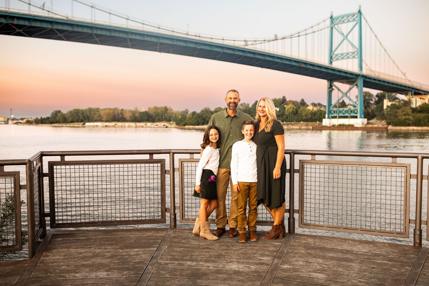 Family portrait at sunset by the river with a Toledo bridge in the background
