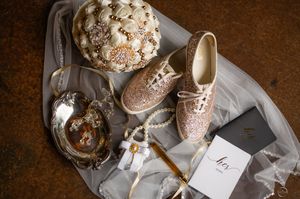 Flat lay of glittery bridal accessories including shoes, bouquet, and wedding stationery.