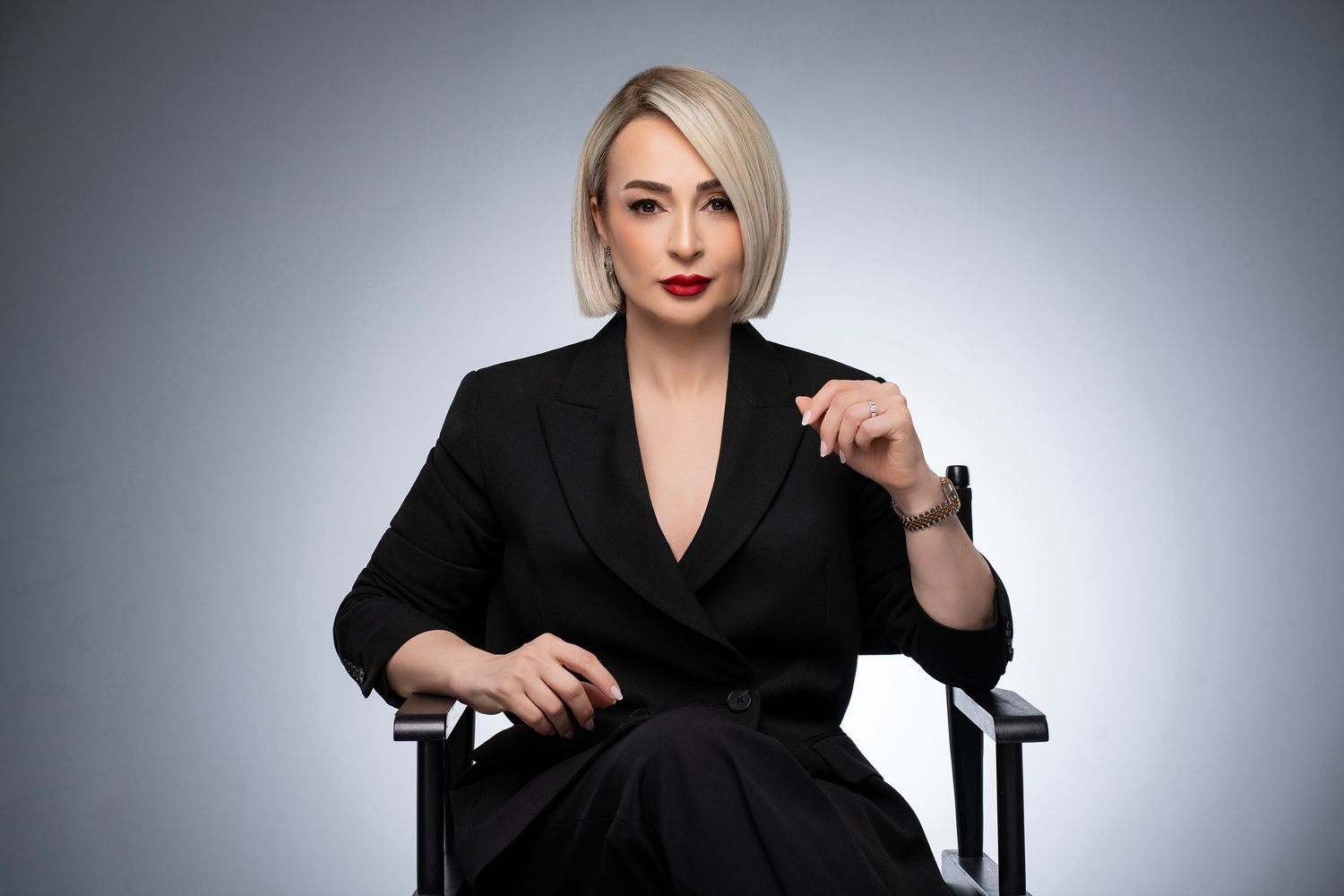 Studio portrait series featuring woman in black wrap dress against gray background.