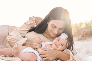 Intimate family portraits on sandy beach with dreamy sunlit atmosphere.